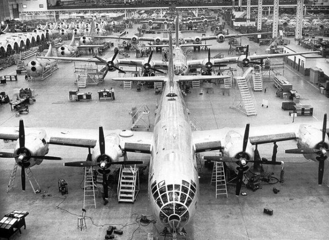 Black and white photo of an aircraft assembly line.